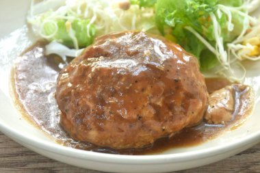 Izgara pirzola, biftek soslu sos ve tabakta salata.