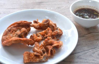 Baharatlı tamarind soslu un kaplı kızarmış domuz iç organları. 