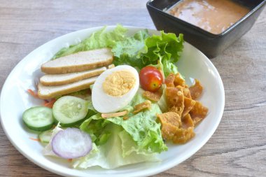 Haşlanmış yumurta, çıtır çıtır taro soslu Hint soslu salata. 