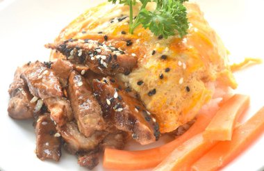 Izgara domuz eti, yumurta ve susamlı soslu teriyaki sosu Japon pilavının üzerine.