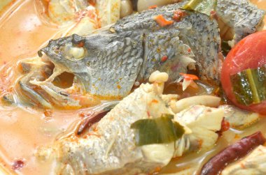 Kaynamış levrek balığı kafası ve mantar tabakta Tom yum çorbası