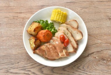 Kızarmış tavuk bifteği sos sosu, marul ve haşlanmış patatesli mısır. 