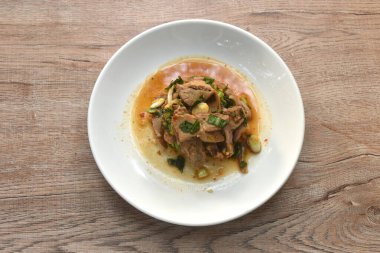 Pirzola ve acılı Tayland salatası dilimlenmiş domuz eti. Tabakta baharatlı ve ekşi.