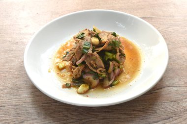 Pirzola ve acılı Tayland salatası dilimlenmiş domuz eti. Tabakta baharatlı ve ekşi.