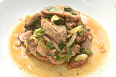 Pirzola ve acılı Tayland salatası dilimlenmiş domuz eti. Tabakta baharatlı ve ekşi.