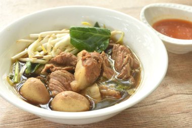 haşlanmış domuz eti ve tendon çift organı baharatlı acı biber sosuna batırılmış, kahverengi şifalı çorba. 