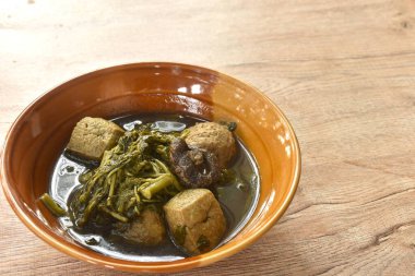 Çin bitkisel çorbasında siyah mantarlı soya peynirli ıspanak. 