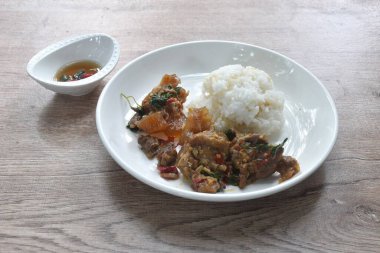 Baharatlı kızarmış et ve fesleğen yaprağı ve biberli tendon. Tabakta çift pilav yiyorlar.  