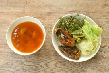 Kızarmış yılan başı balığı ve yumurta doldurulmuş tırmanma gerdanlığı tabakta baharatlı ekşi çorba.