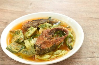 Kızarmış yılan başı balığı ve yumurta doldurulmuş tırmanma gerdanlığı tabakta baharatlı ekşi çorba.