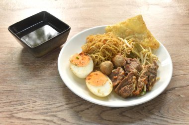 Haşlanmış Çin yumurtalı erişte, haşlanmış sığır eti ve köfte soslu siyah soya soslu tabak üzerine yumurta.