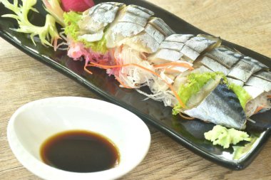 Namizen saşimi ya da saba uskumrusu dilimlemek Japon yemeği üzerine pirzola, wasabi sosu ve soya sosu tabakta. 