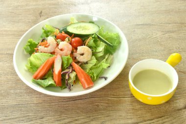 Kaynamış karides ve yengeç çubuğu. Sebze deniz ürünleri salatası ve krema sosu.