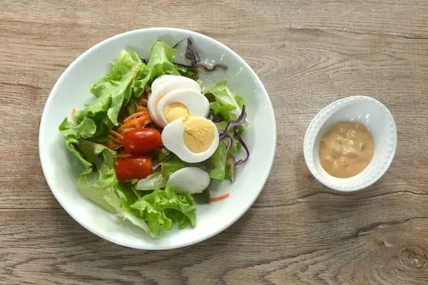 Kaynamış yumurta ve sebze soslu ada salatası.