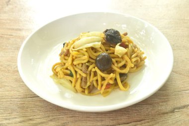 Kızarmış yakisoba Japon eriştesi ve tabağında mantar olan lahana.