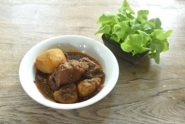 Körili biftek ya da Hint yemeği dilimlenmiş patates ve taze yeşil meşe ile yenir.