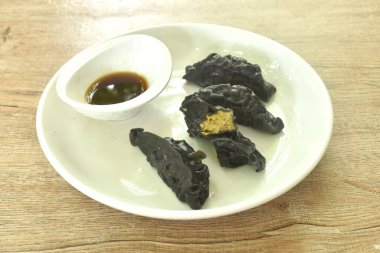 Buharda pişmiş mürekkep balığı Gyoza ya da Japon hamur tatlısı doldurulmuş körili domuz püresi Shoyu sosu tabakta. 