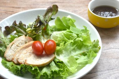 Izgara tavuk göğsü ve tabakta sebze salatası Japon susam yağı sosu.