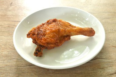 Çıtır çıtır kızarmış tavuk ve tabakta otla mayalanan bacak. 