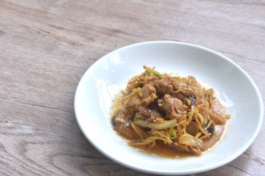 Dilimlenmiş zencefilli kızarmış tavuk ve tabakta siyah kulak mantarı.