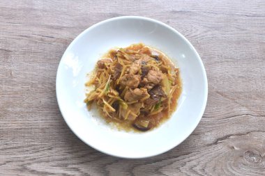 Dilimlenmiş zencefilli kızarmış tavuk ve tabakta siyah kulak mantarı.