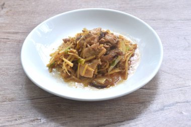 Dilimlenmiş zencefilli kızarmış tavuk ve tabakta siyah kulak mantarı.