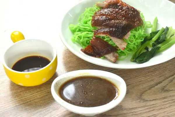 Çin yeşim eriştesi. Kızarmış ördek eti. Tabağa soya sosu bandırıyor. 