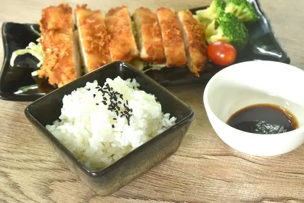 Kızarmış tavuk ve un ya da karaage Japon yemeği pirinç soslu siyah susamlı tatlı siyah soya soslu sebze.