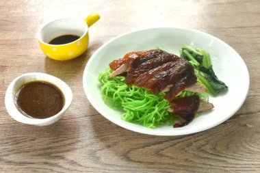 Çin yeşim eriştesi. Kızarmış ördek eti. Tabağa soya sosu bandırıyor. 