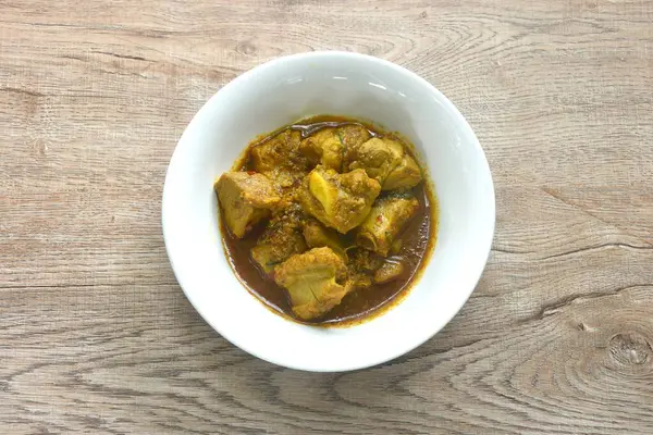 Baharatlı domuz kemiği, sarı köri ve fesleğen yapraklı Tayland yemeği. 