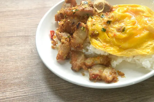 Acı biberli ve sarımsaklı kızarmış domuz eti ve sade pirinç soslu kremalı yumurta omleti.