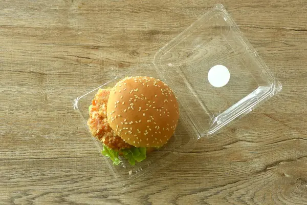 Kızarmış karides püresi hamburger ve mayonez doldurulmuş mayonez sosu ve masada plastik paketler içinde ketçap.