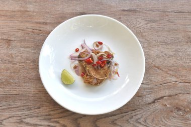 Tuzlu kuru Hint-Pasifik kral uskumrusu pirzola ve kırmızı biberli ve dilimlenmiş limon salatası tabağında. 