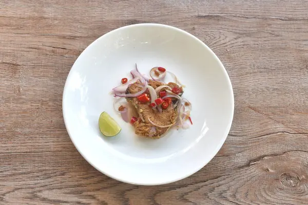 Tuzlu kuru Hint-Pasifik kral uskumrusu pirzola ve kırmızı biberli ve dilimlenmiş limon salatası tabağında. 