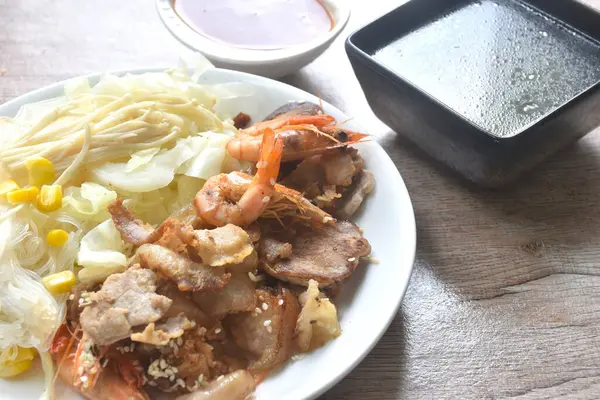 Kore usulü kızarmış domuz eti, lahana ve cam erişteli baharatlı sos çorbası.