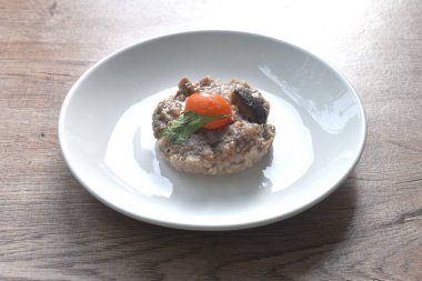 Buharda pişmiş domuz pirzolası, tuzlu yumurta sarısı, siyah mantar ve sos tabağı.