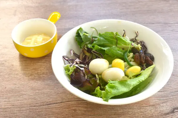 Kaynamış bıldırcın yumurtası, sebze salatası ve mayonez sosu sosu.