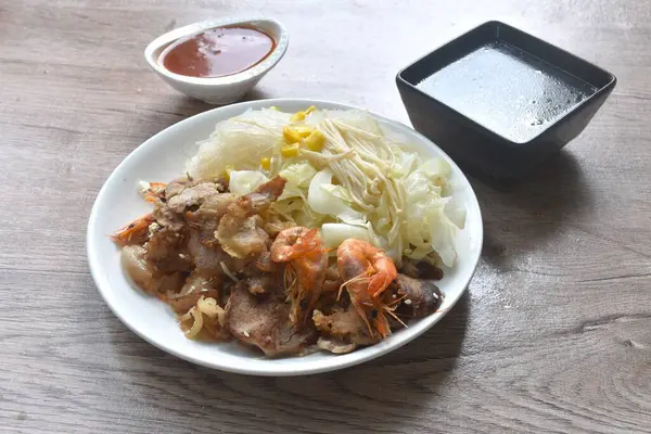 Kore usulü kızarmış domuz eti, lahana ve cam erişteli baharatlı sos çorbası.