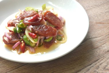 Baharatlı ve ekşi tatlı Çin domuz sosisi ve tabakta sebze salatası.  