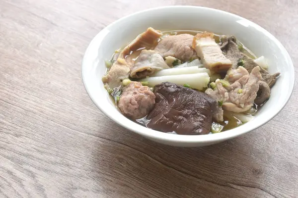 Büyük pirinç erişteleri, pirzola ve domuz eti. Temiz çorba ve kase üzerinde kan.   