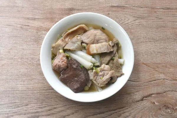 Büyük pirinç erişteleri, pirzola ve domuz eti. Temiz çorba ve kase üzerinde kan.   