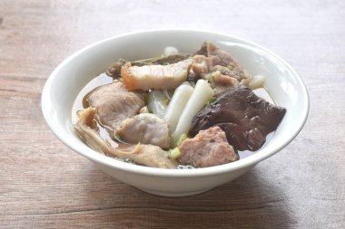 Büyük pirinç erişteleri, pirzola ve domuz eti. Temiz çorba ve kase üzerinde kan.   