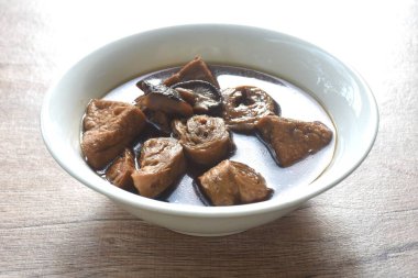 Haşlanmış soya peyniri ve siyah mantarlı glüten çorbası kasede vejetaryen yemeği.