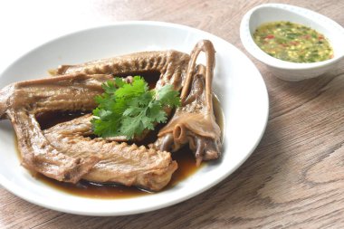 Haşlanmış ördek kanadı ve gagalı kahverengi soya çorbası baharatlı acı biber sosu. 