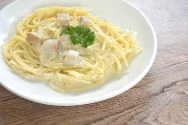 Buharda pişirilmiş spagetti beyaz kabonara krema sosu dilimlenmiş mantar sosu tabakta 