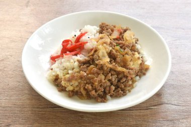 Soğanlı kızarmış kıyma ya da pilav üzerine soboro donburi üzerine siyah susamlı turşulu kırmızı zencefil.