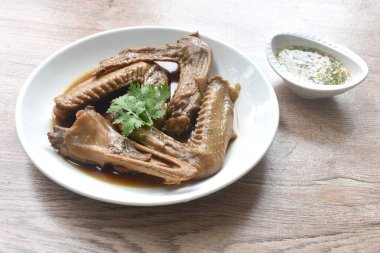 Haşlanmış ördek kanadı ve gagalı kahverengi soya çorbası baharatlı acı biber sosu. 