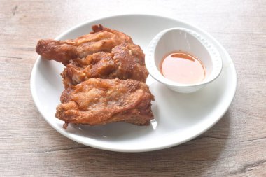 Kıtır kıtır kızarmış tavuk ve bacağı tabakta tatlı acı biber sosuna batırılmış.