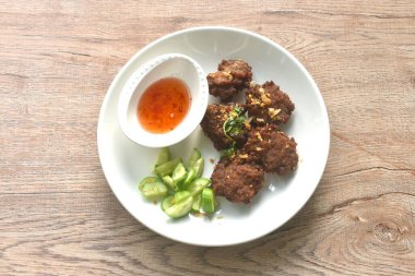 Kızarmış tuzlu pirzola, sarımsaklı, acı biber soslu ve tabakta salatalık dilimlenmiş domuz eti.