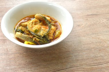 Baharatlı biber, patlıcan ve fesleğen ile kaynatılmış yayın balığı.